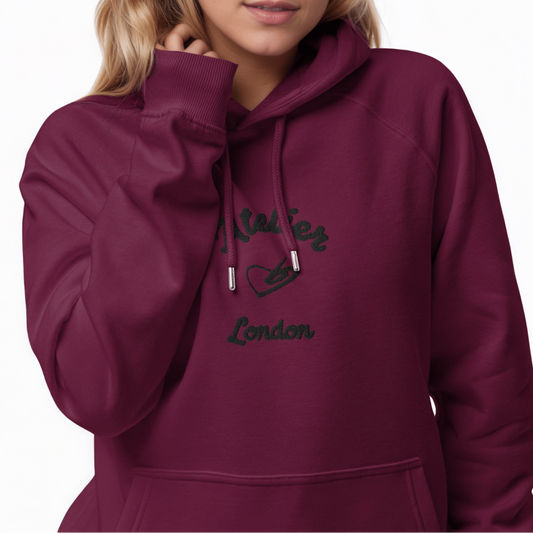 A model wearing The Atelier Hoodie showing the branded atelier heart logo