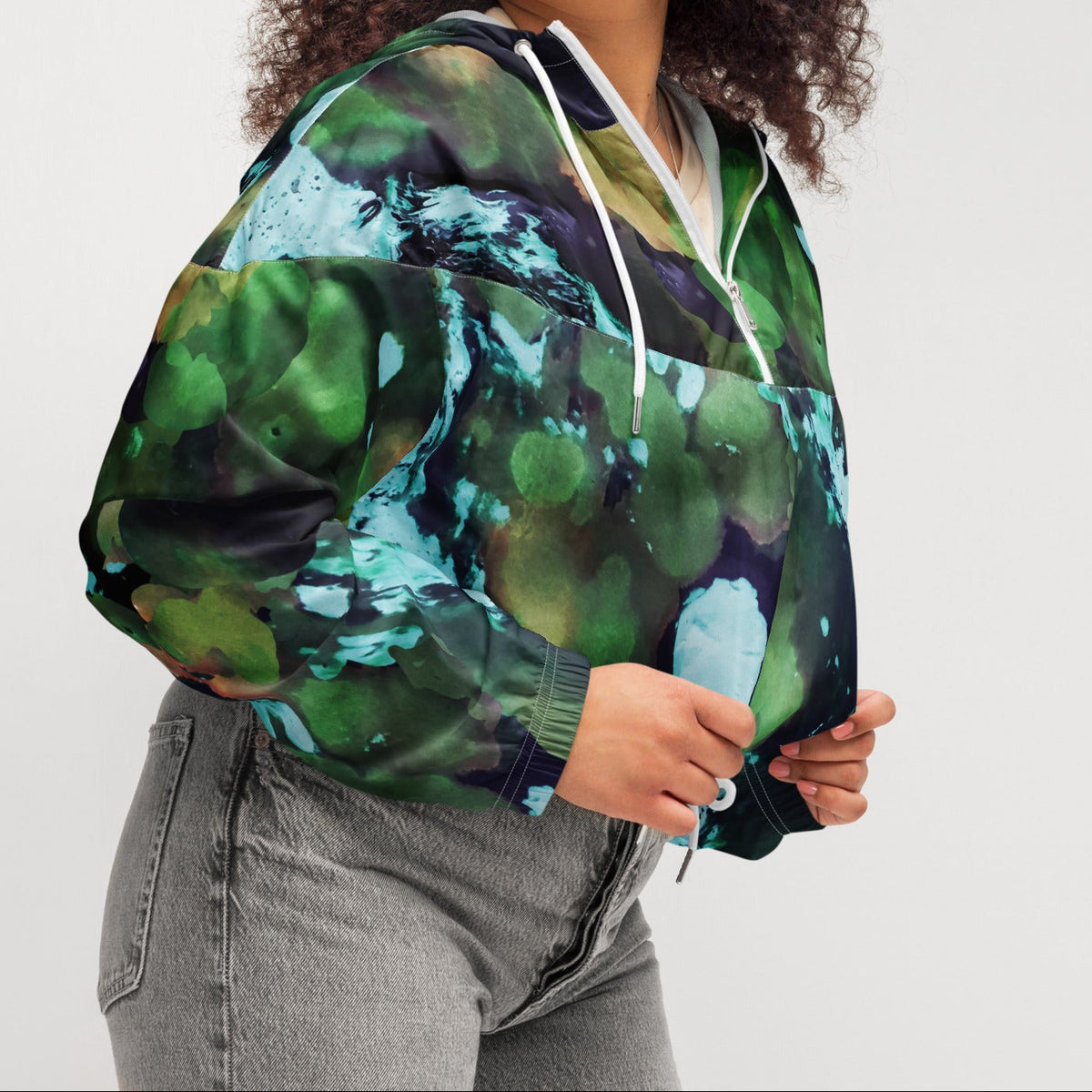 A model wearing The Abstract Crop Shell, showing the high-fashion, cropped silhouette and the abstract expressionism print in green and blue hues.