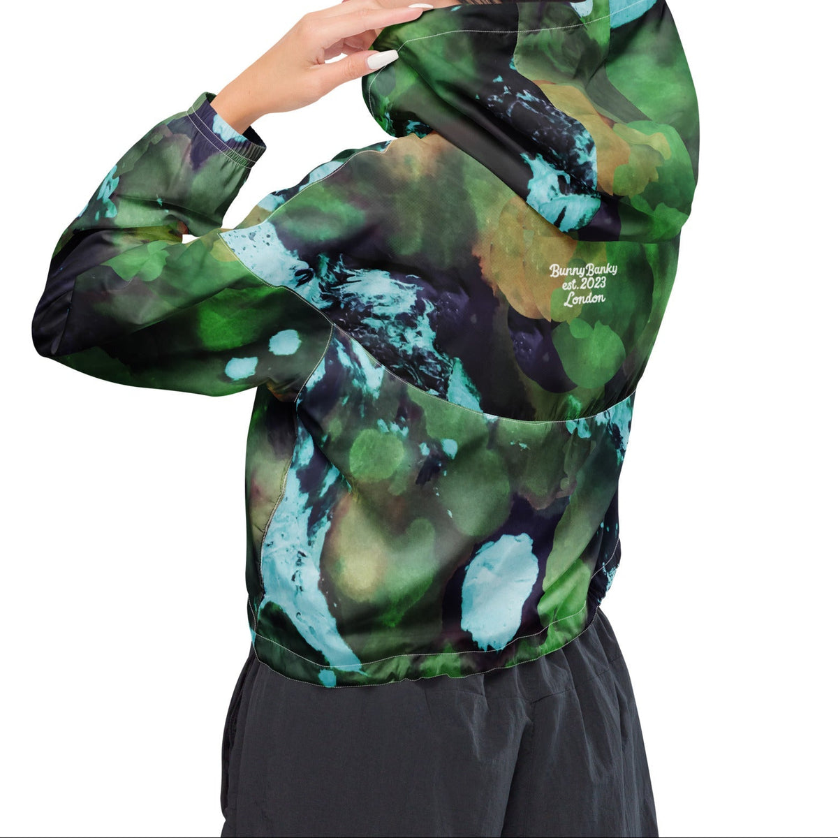 A model wearing The Abstract Crop Shell, showing the high-fashion, cropped silhouette and the abstract expressionism print in green and blue hues.
