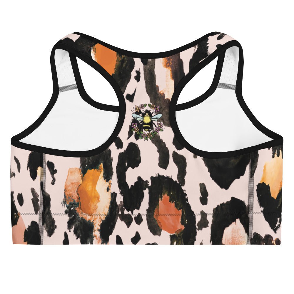 A close-up of the back of The Amazonia Performance Bra, highlighting the small bee print and the secure racerback design on the animal print fabric.