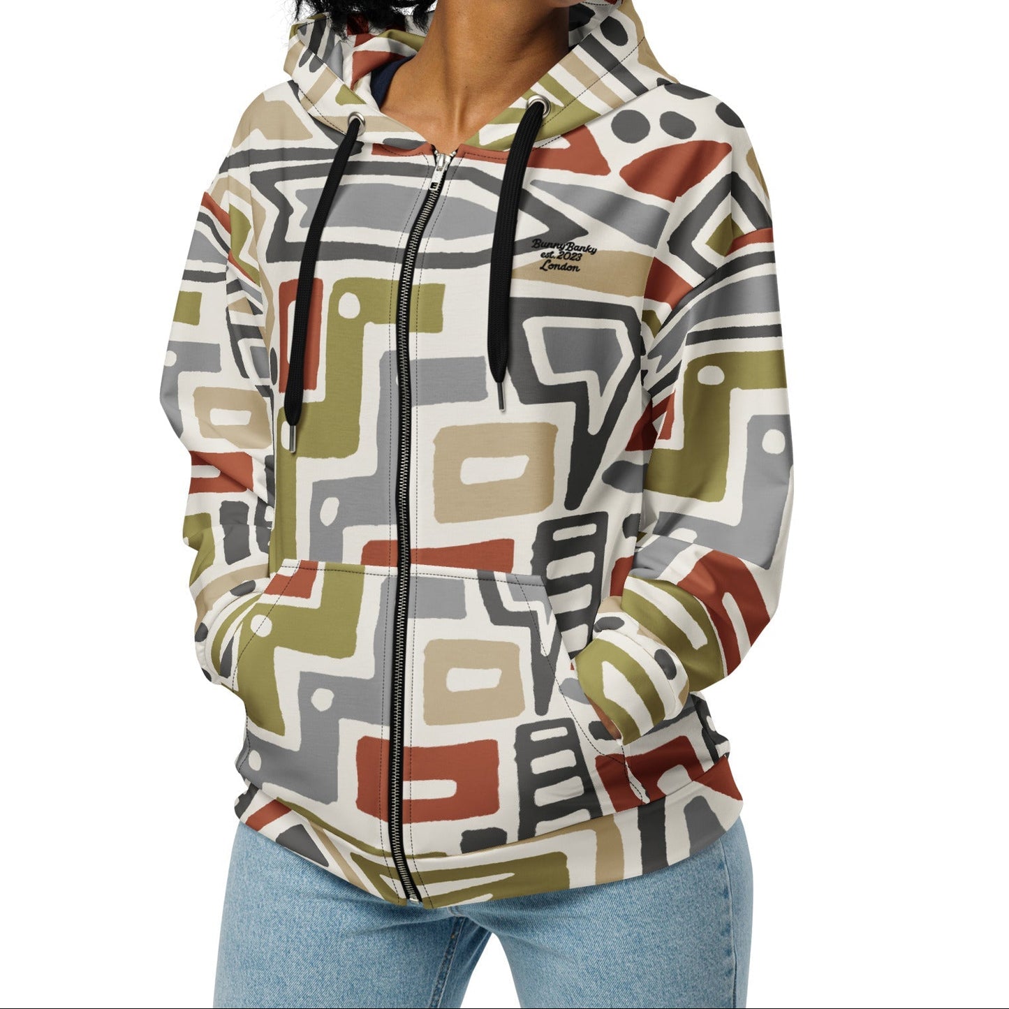 A model wearing The Amsterdam Zip Hoodie from BunnyBankY, showing the secure fit and the geometric futurism pattern in rich, earthy tones.