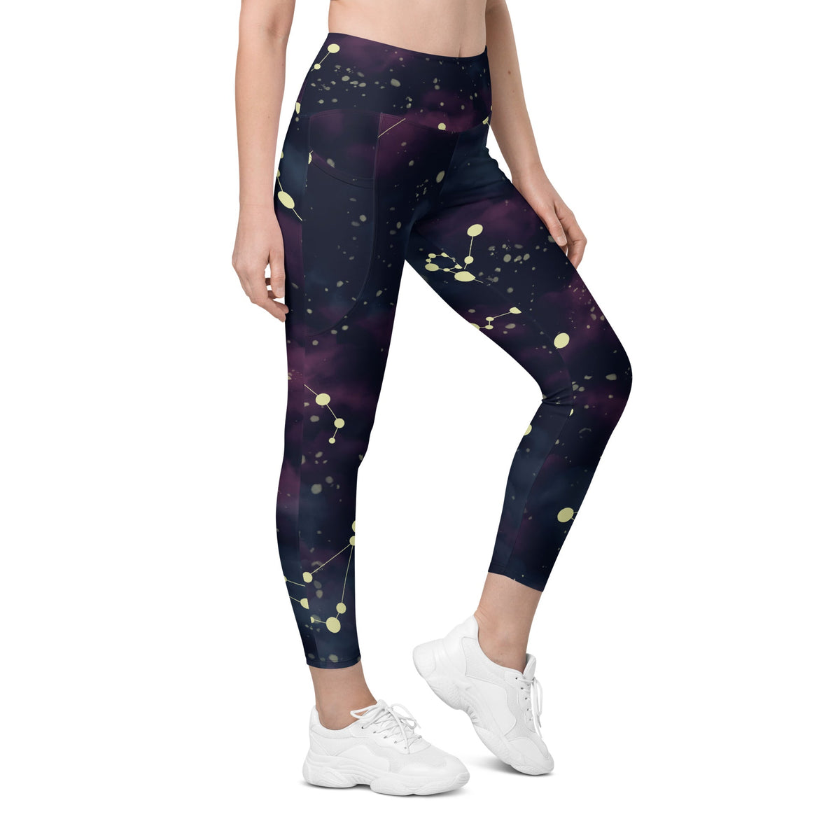 A model wearing The Andromeda Sculpt Leggings, showcasing the sculpting fit and the distinctive yellow star constellation print on the dark purple-to-black gradient fabric. The background features a subtle cosmic nebula.