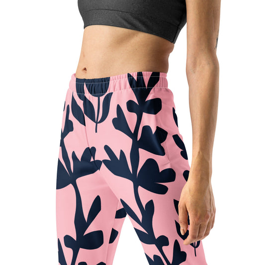 A model wearing The Kensington Glide Joggers, showing the slim fit and the bold, high-contrast pink and blue oversized floral print.