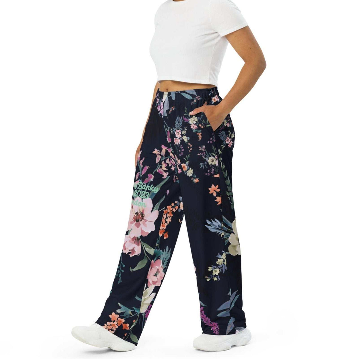 A model wearing the Kew Botanical Wide Leg Joggers. The image highlights the cohesive floral print across joggers, emphasizing the premium drape of the wide-leg cut.