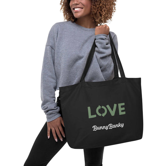 Woman carrying black The Manifesto Tote with LOVE and BunnyBanky print