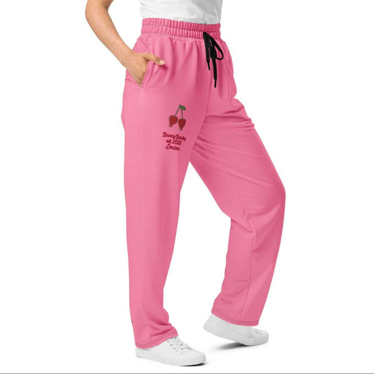 A model wearing The Seoul Pink Flow Wide Joggers, showing the wide-leg cut and the playful Pop Cherry print and binary code on the vibrant pink fabric.
