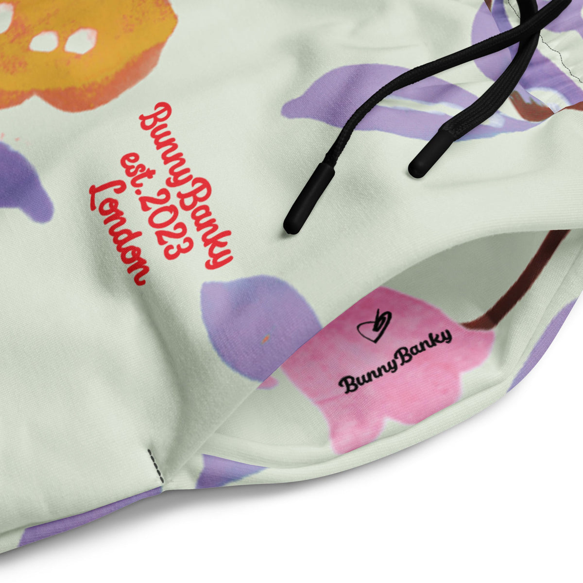 A close-up of The Sloane Square Flow Wide Joggers, highlighting the soft texture and the elegant pastel pink and lilac oversized floral print.