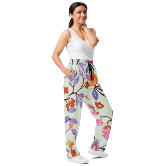 A model wearing The Sloane Square Flow Wide Joggers, showing the relaxed, wide-leg cut and the oversized pink and lilac floral print.