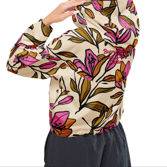 A model wearing The Terra Shell, showing the lightweight fit and the vibrant bubblegum pink tropical floral print on the beige fabric.