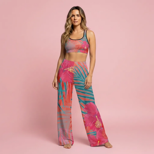 A BunnyBankY AI proprietary model wearing the District Tropics Wide-Leg Joggers and matching performance bra. The image highlights the flowing silhouette and the vibrant pink, orange, and blue tropical floral pattern.