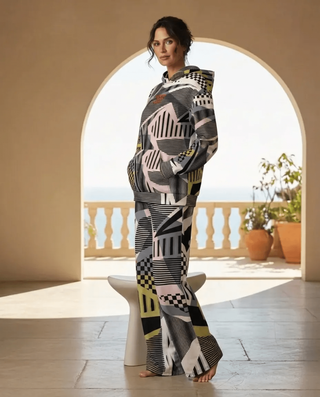 A BunnyBankY AI proprietary model wearing the full Sydney Set, featuring the oversized hoodie and matching wide-leg joggers. The image showcases the cohesive Art Deco pattern of monochrome checkerboards, pinstripes, and soft sand and blush tones in a high-fashion, relaxed silhouette.