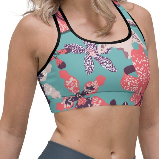 Model wearing the Chelsea Performance Bra featuring  a tropical print and racer back against a white background.