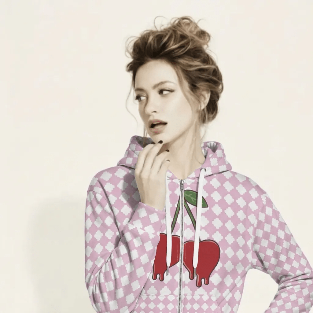 A BunnyBankY AI proprietary model wearing the cherry bomb zip hoodie featuring a pink and white geometric clover pattern, a dripping heart-cherry graphic on the front, and 