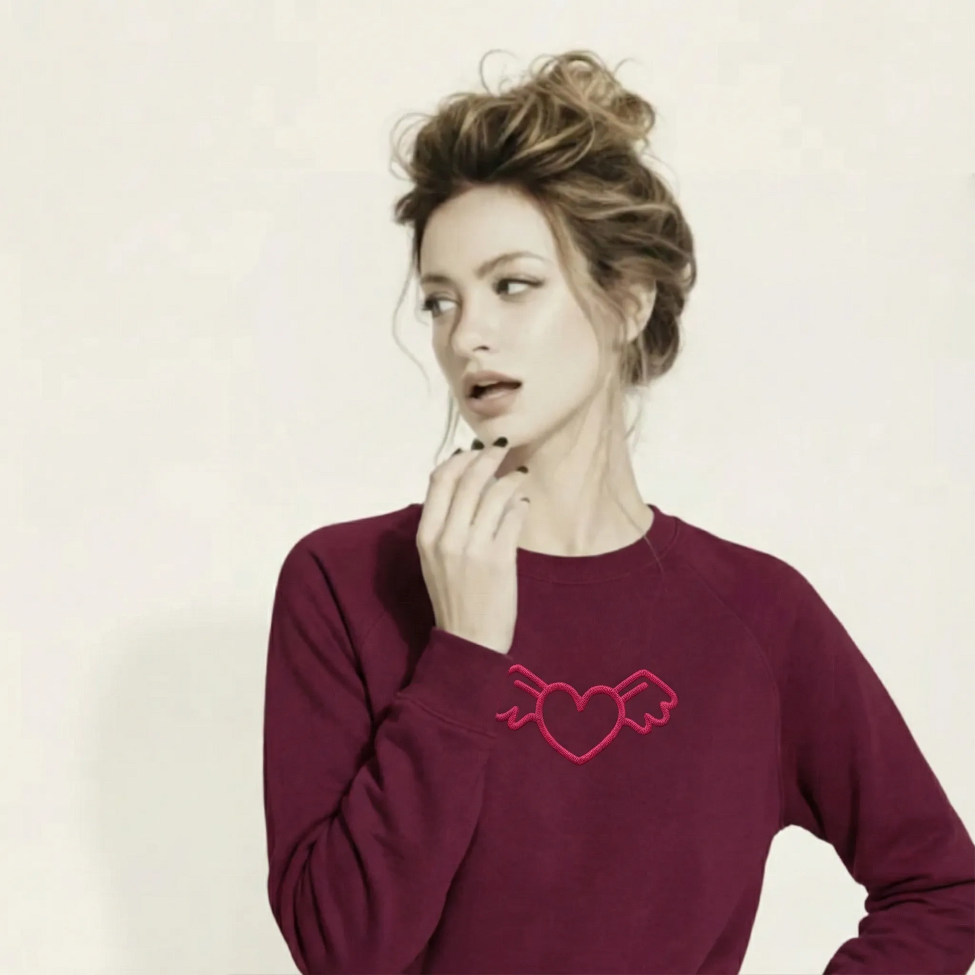 A BunnyBankY AI proprietary model wearing The Monument Organic Sweatshirt, showing the relaxed, premium fit and the "Winged Heart" embroidery in vibrant pink