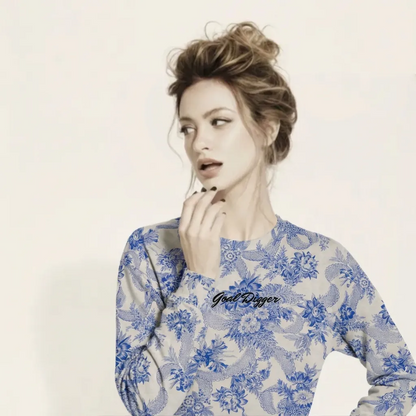 A BunnyBankY AI proprietary model wearing The Saint Germain Sweatshirt, highlighting the "Goal Digger" embroidery on blue floral pattern on cream fabric and the iconic signature logo at the back.