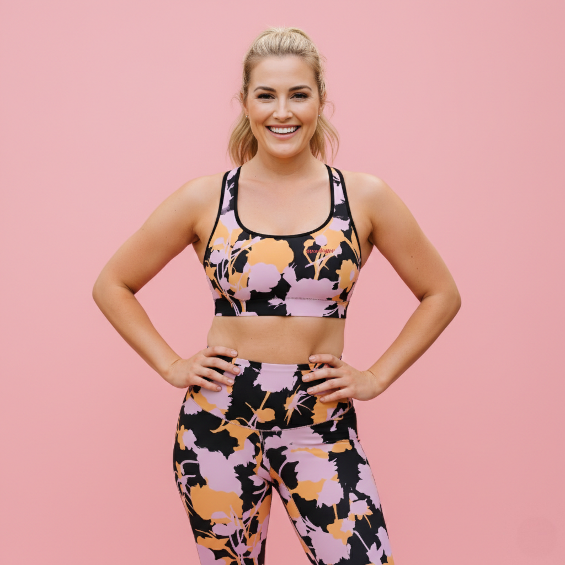 AI BunnyBankY model wearing The Miami Performance Bra, showing the supportive fit and the vibrant pink and orange splashes print.