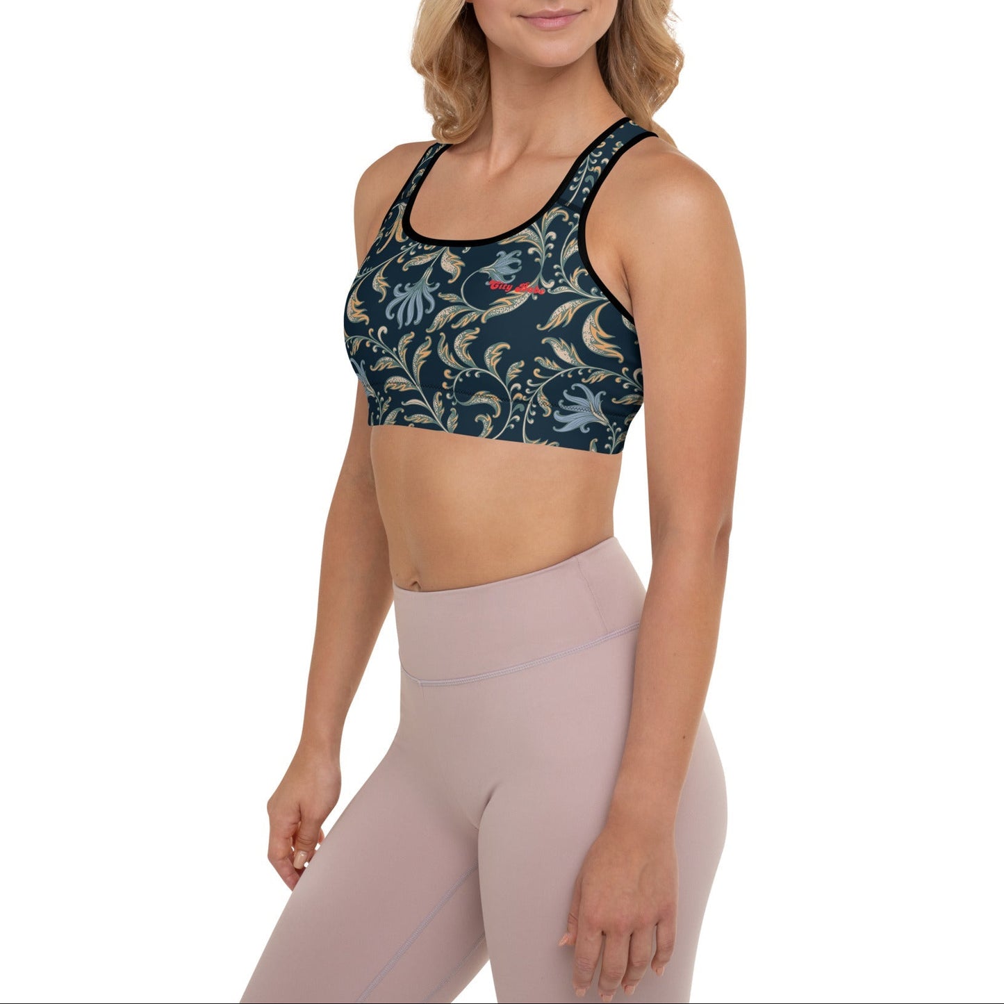 Model wearing the Venice Perfromance Bra featuring a parsly and floral pattern in dark blue with beige and light blue details, and the text City Babe at the top left.