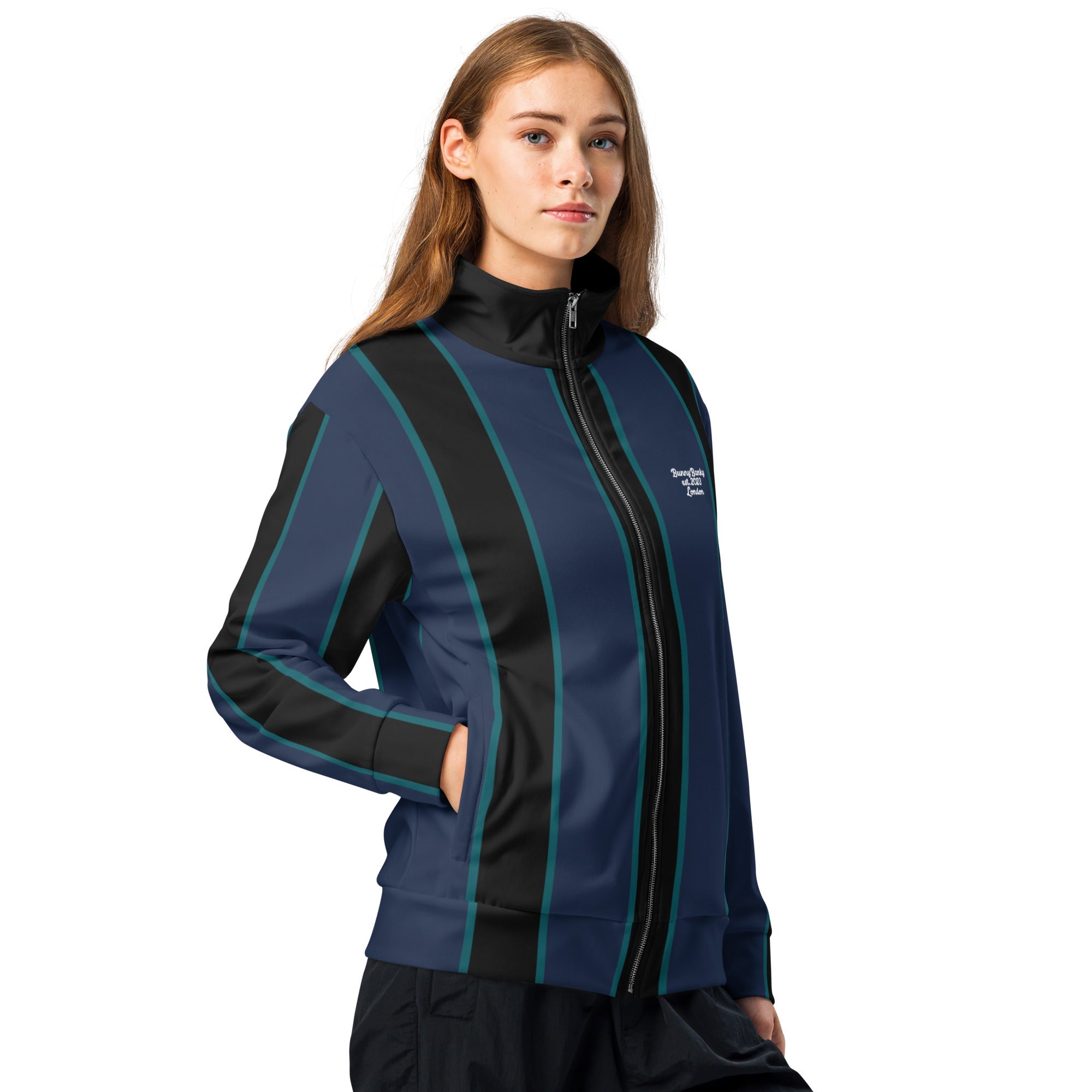 A model wearing The Regent Track Jacket, showing the premium slim fit, full-zip closure, and the vertical green and blue stripe print on the navy background.