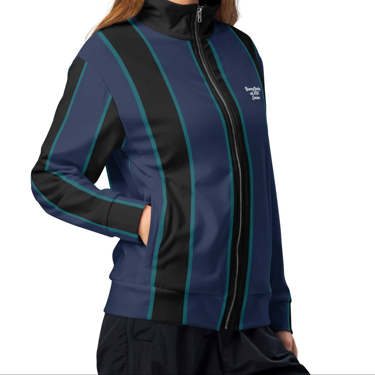 A model wearing The Regent Track Jacket, showing the premium slim fit, full-zip closure, and the vertical green and blue stripe print on the navy background.