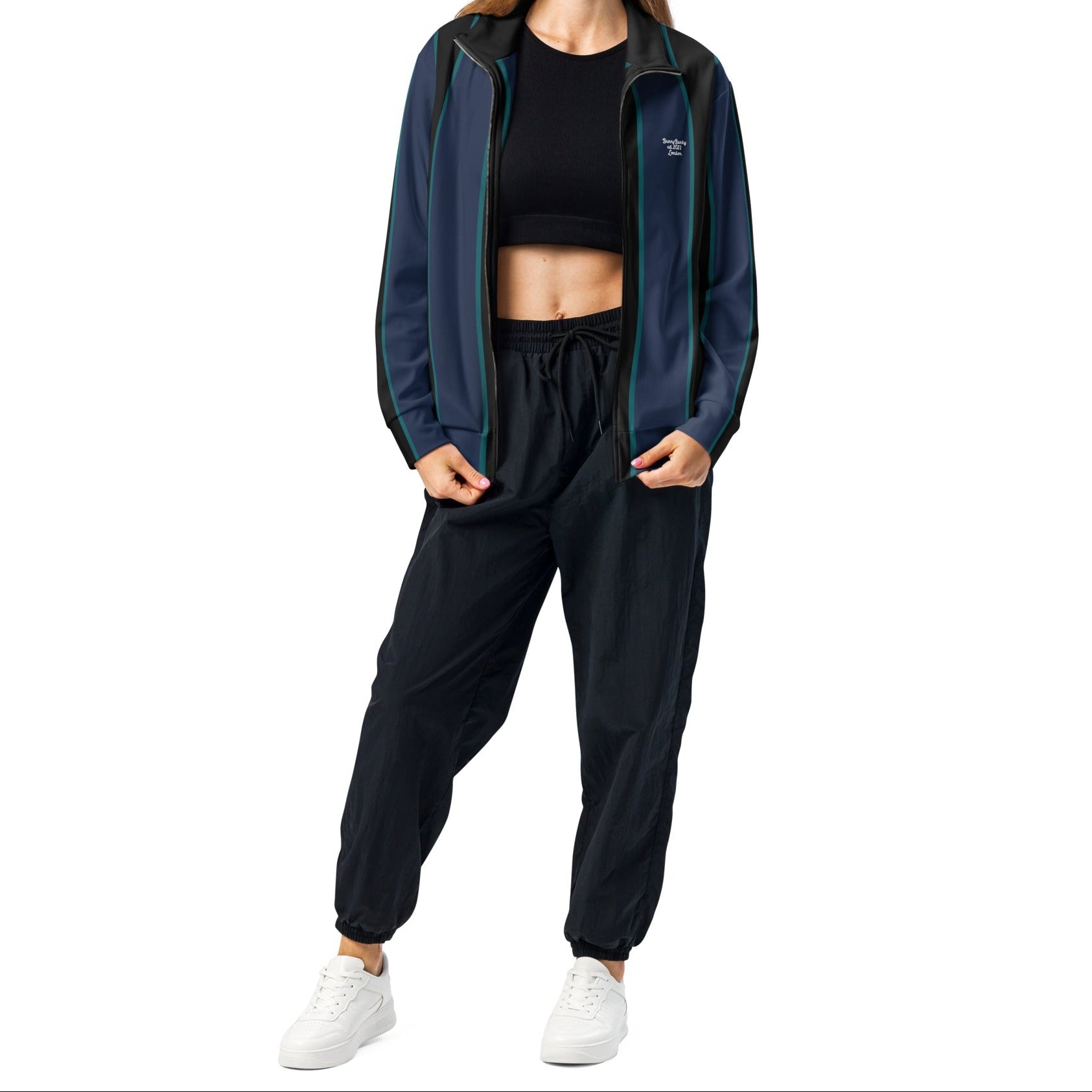 A model wearing The Regent Track Jacket, showing the premium slim fit, full-zip closure, and the vertical green and blue stripe print on the navy background.