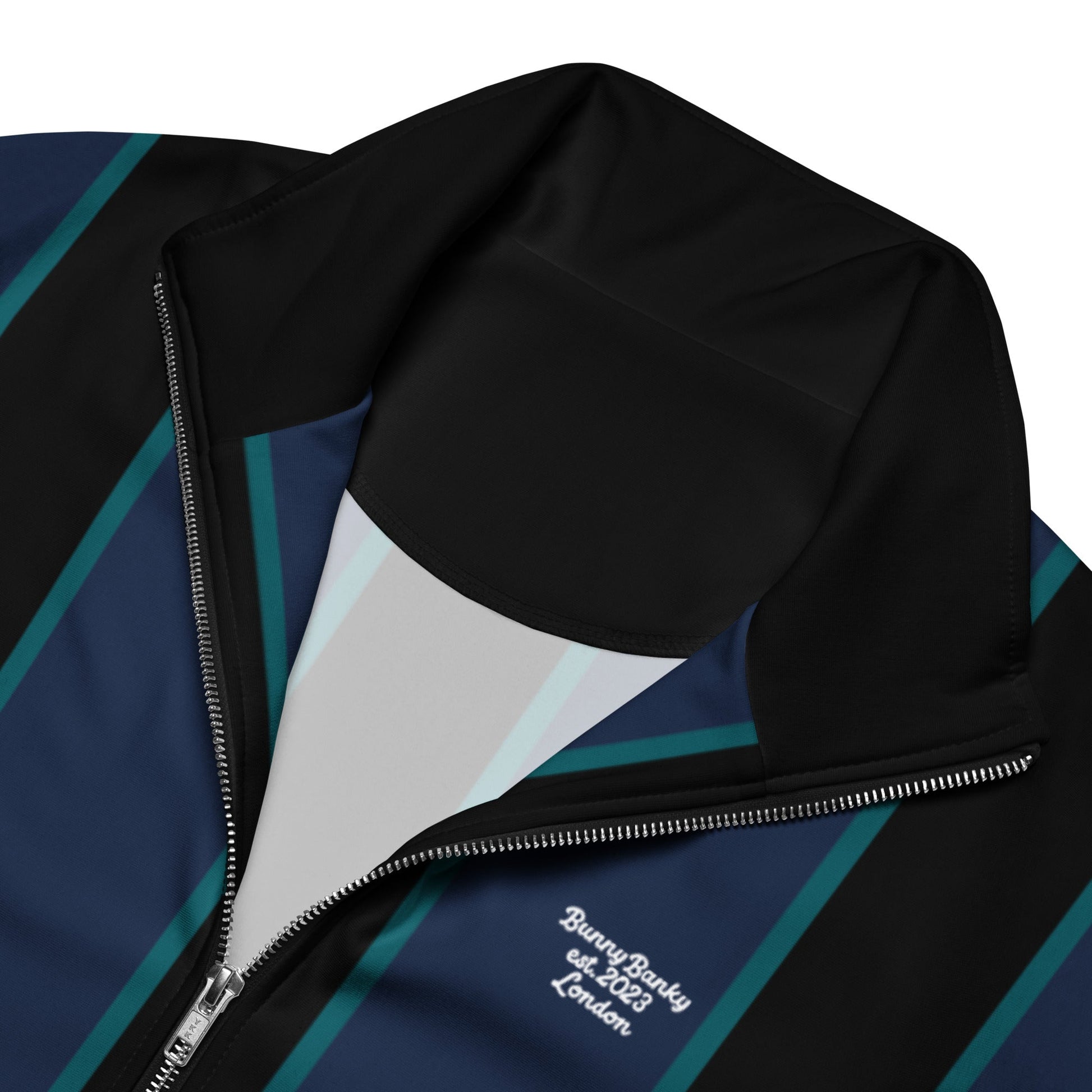 A close-up of the recycled polyester fabric of The Regent Track Jacket, showing the soft, smooth exterior and the striking vertical stripe pattern.