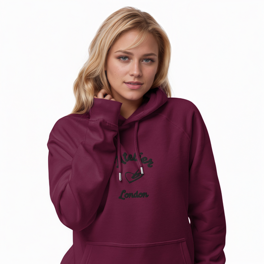 A model wearing The Atelier Hoodie showing the branded atelier heart logo