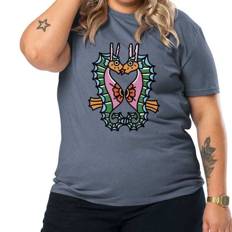 A denim blue organic t-shirt featuring a symmetrical graphic of two colorful seahorses with bunny ears and floral details.