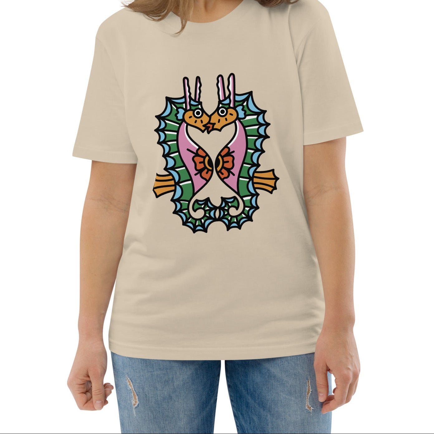 A model wearing the organic t-shirt featuring a symmetrical graphic of two colorful seahorses with bunny ears and floral details in dusty beige.