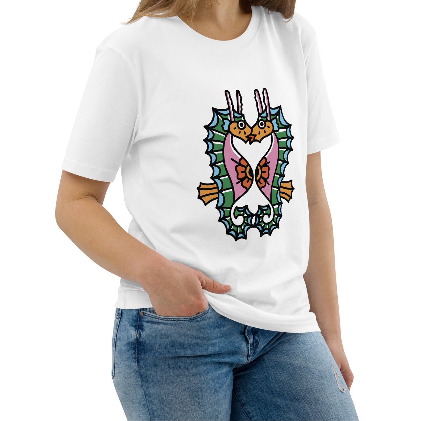 A model wearing the white organic t-shirt featuring a symmetrical graphic of two colorful seahorses with bunny ears and floral details.