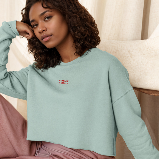 A model wearing The Sisterhood Crop Sweatshirt, showing the raw hem, dropped shoulder cut, and the embroidered "Female Culture" motto on the chest.