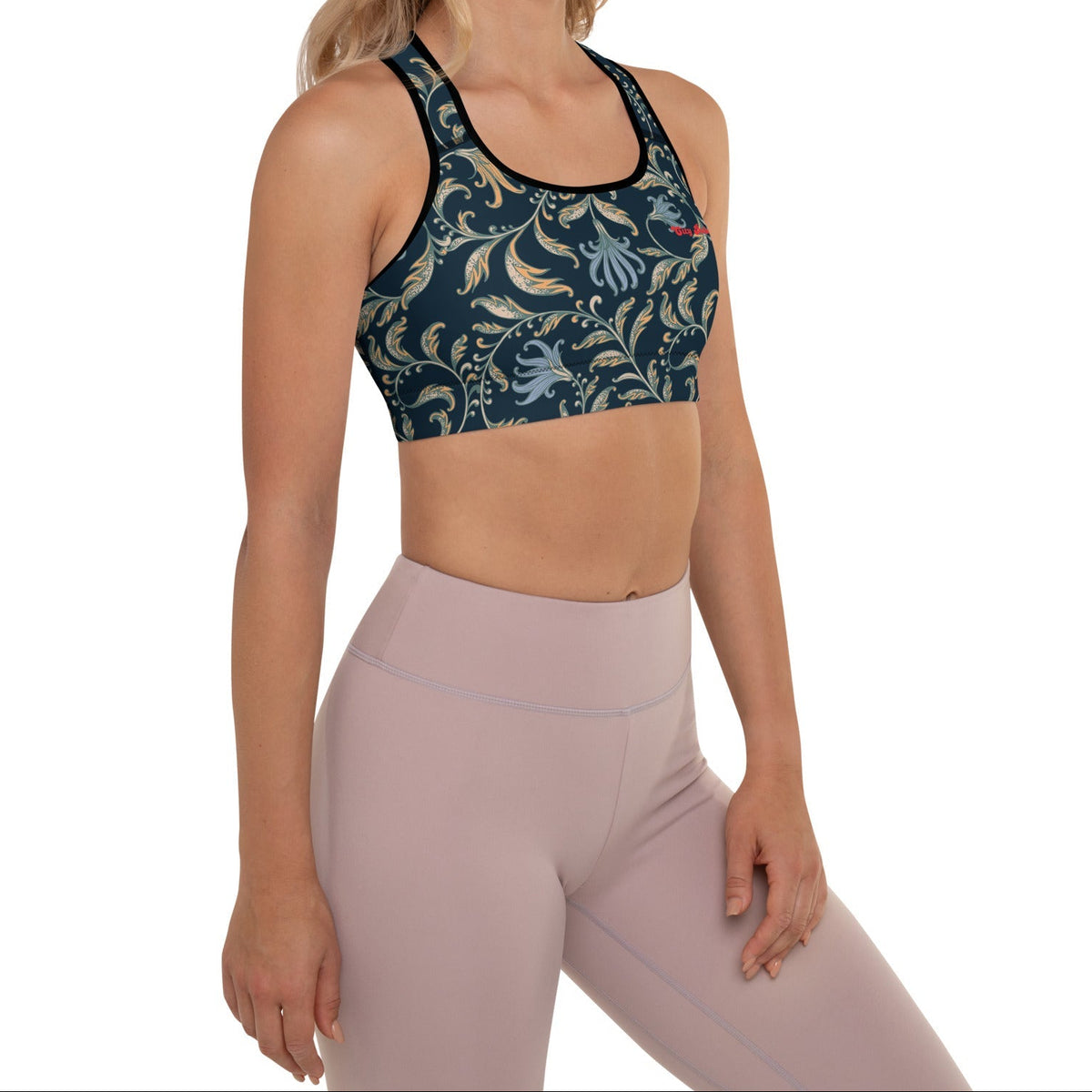 a model wearing the venice performance bra featuring a parsley and floral pattern in dark blue with beige and light blue details, and the text City Babe printed at the top front left side.