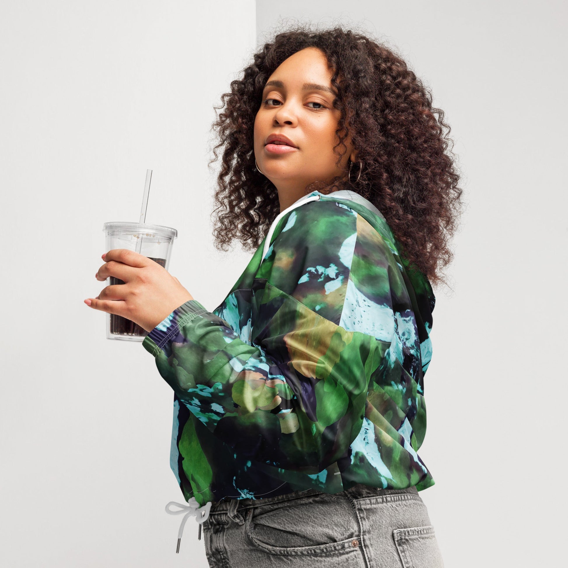 A model wearing The Abstract Crop Shell, showing the high-fashion, cropped silhouette and the abstract expressionism print in green and blue hues.