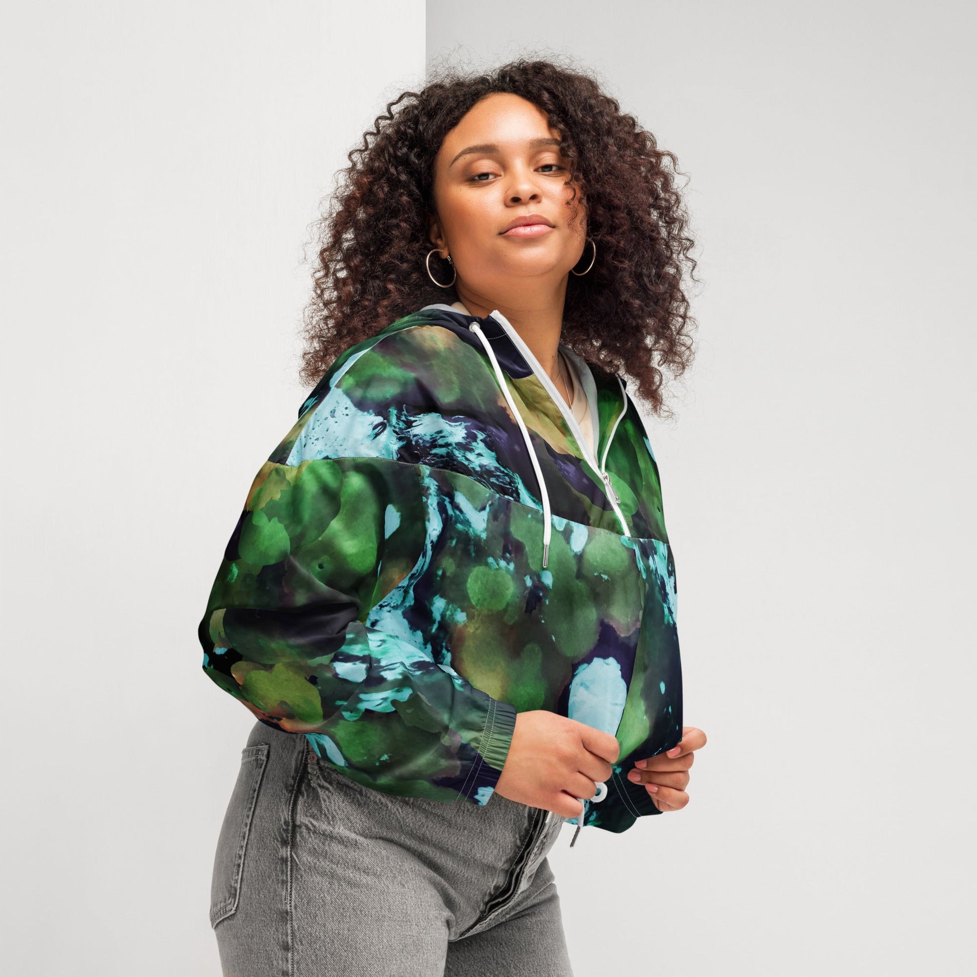 A model wearing The Abstract Crop Shell, showing the high-fashion, cropped silhouette and the abstract expressionism print in green and blue hues.