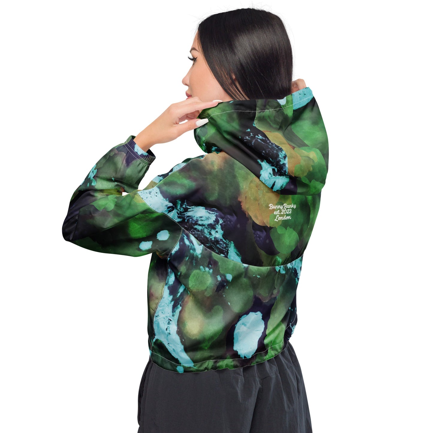 A model wearing The Abstract Crop Shell, showing the high-fashion, cropped silhouette and the abstract expressionism print in green and blue hues.