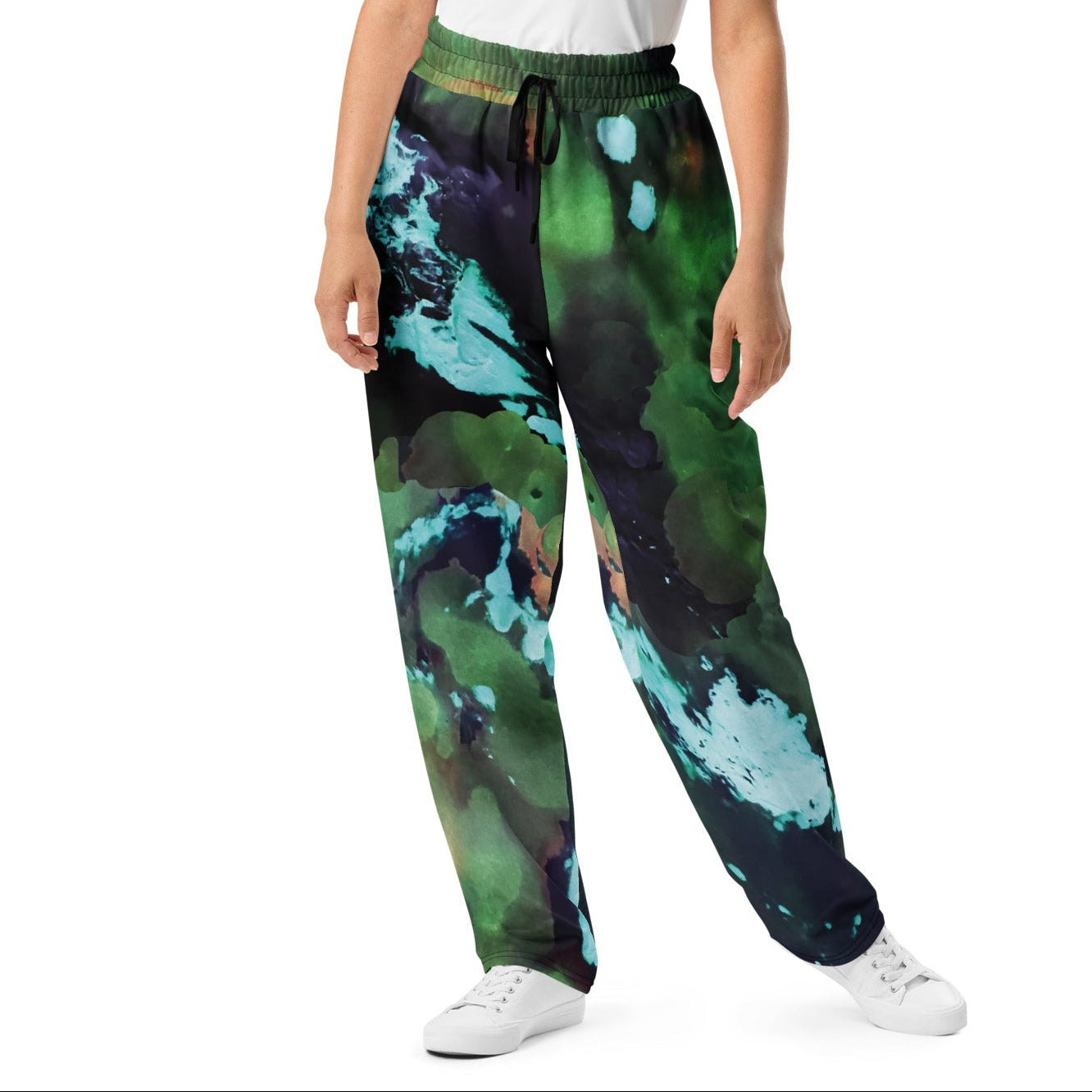 A model wearing The Abstract Flow Joggers, showing the wide-leg cut and the abstract expressionism-inspired print in green and blue hues.