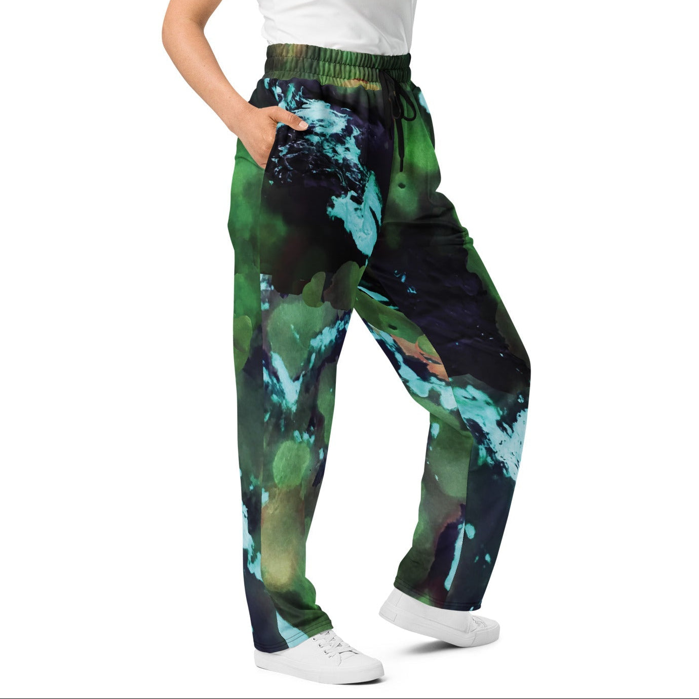 A model wearing The Abstract Flow Joggers, showing the wide-leg cut and the abstract expressionism-inspired print in green and blue hues.