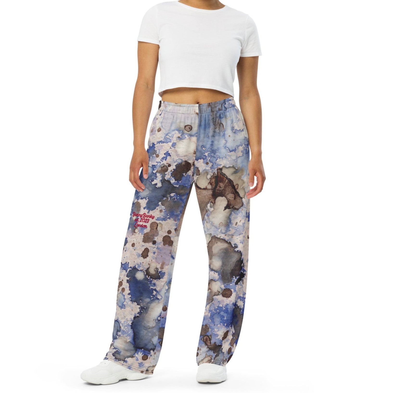 A model wearing the Amalfi Resort flow joggers in a blue and white abstract print  posing against a solid white background.