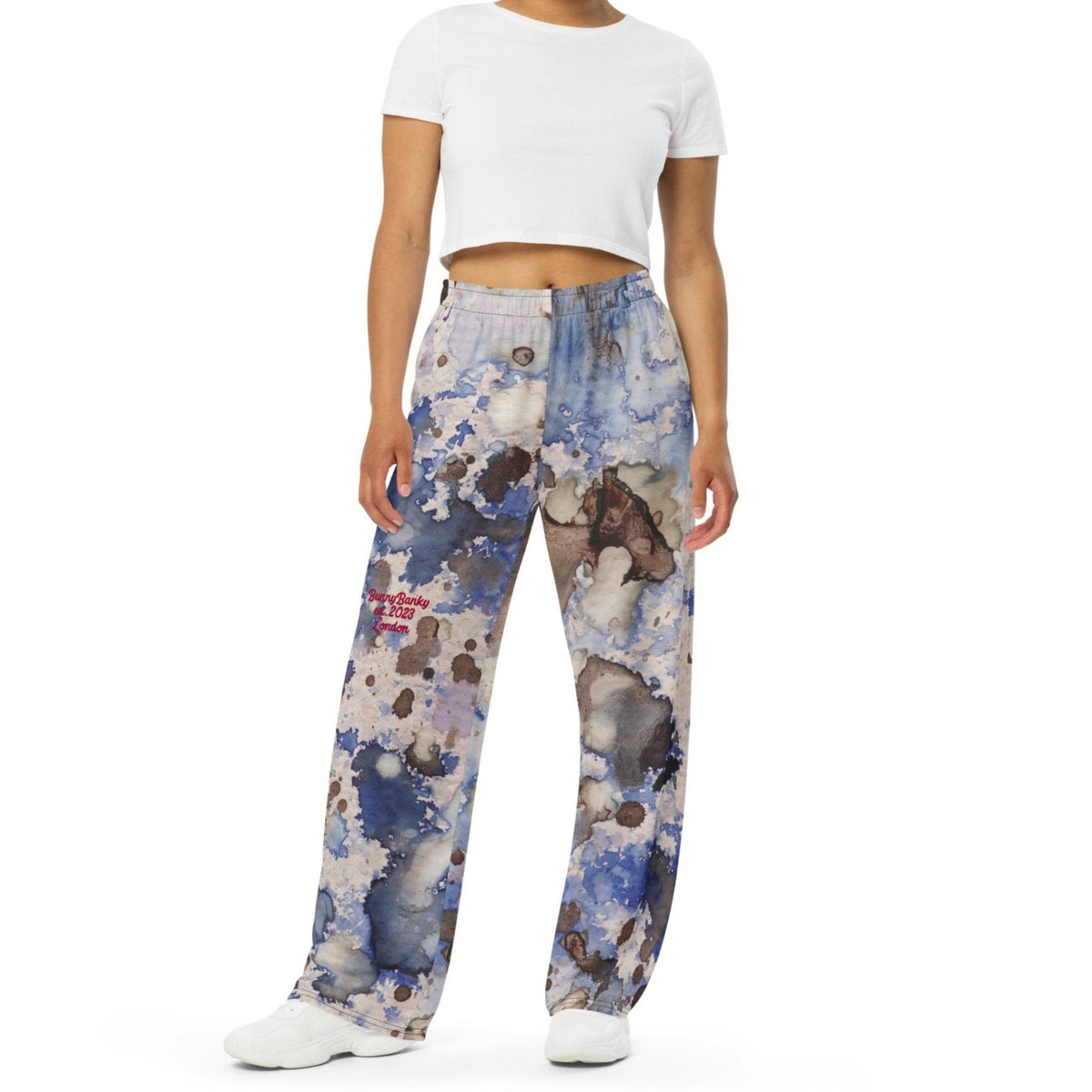 A model wearing the Amalfi Resort flow joggers in a blue and white abstract print  posing against a solid white background.