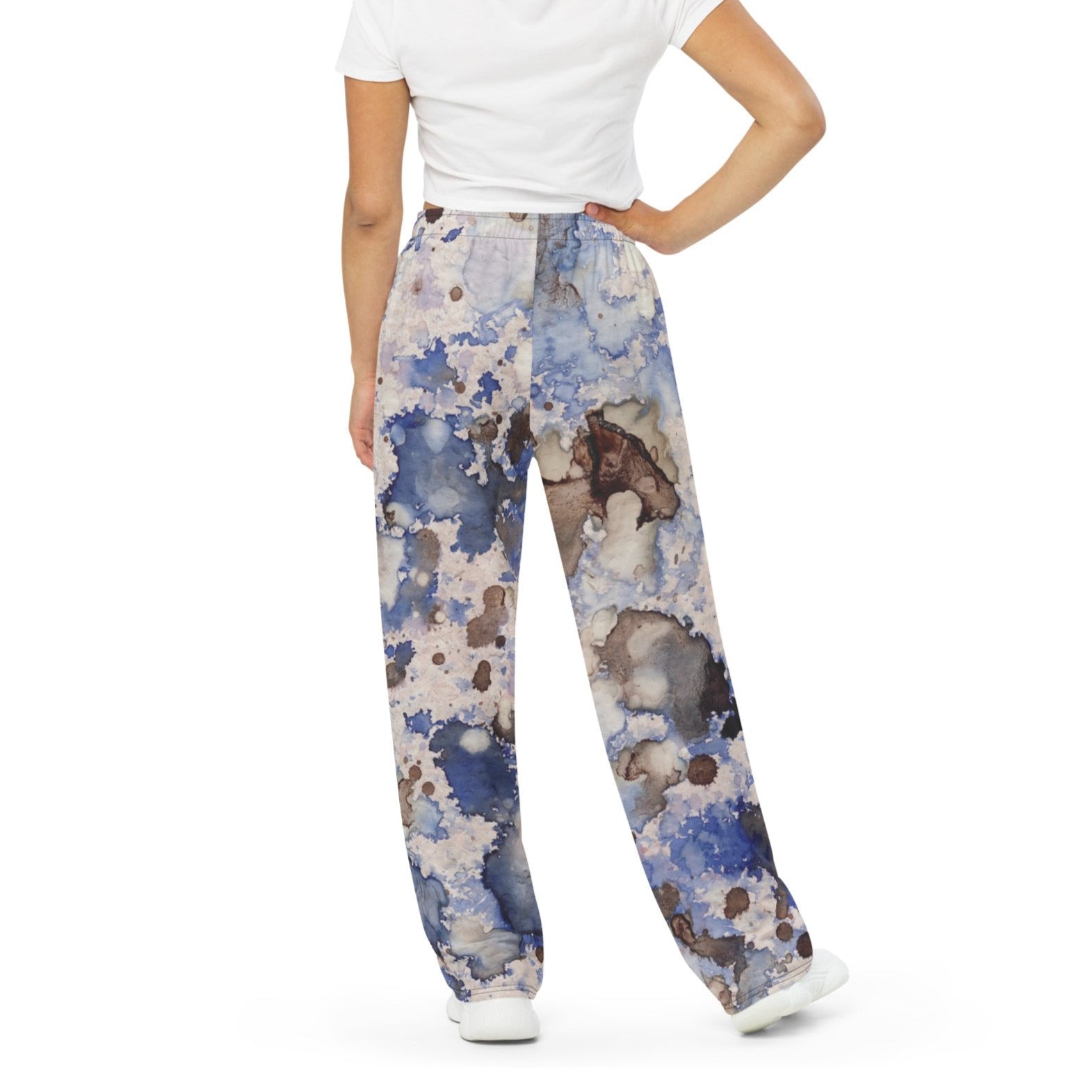A model wearing the Amalfi Resort flow joggers in a blue and white abstract print  posing against a solid white background.