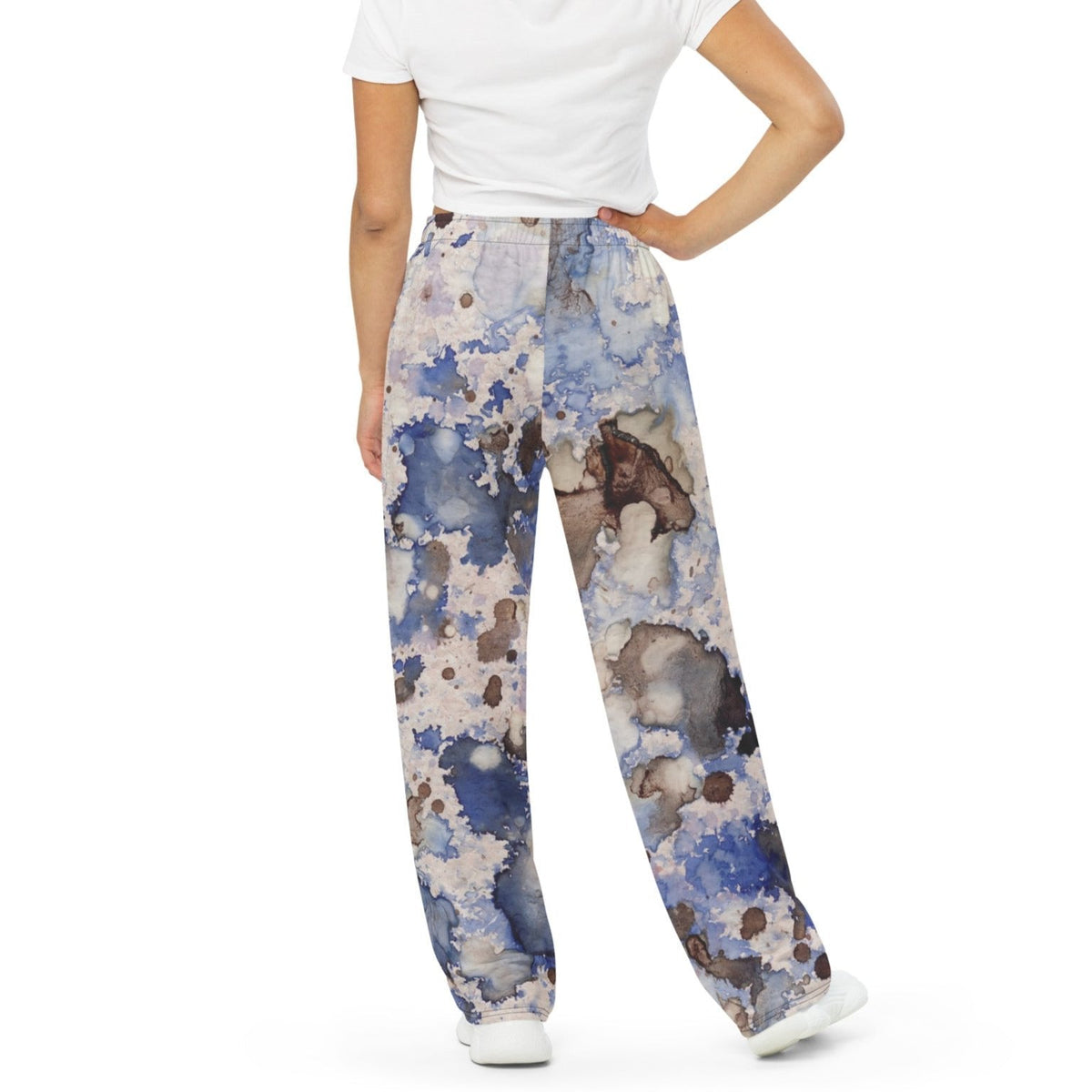 A model wearing the Amalfi Resort flow joggers in a blue and white abstract print  posing against a solid white background.
