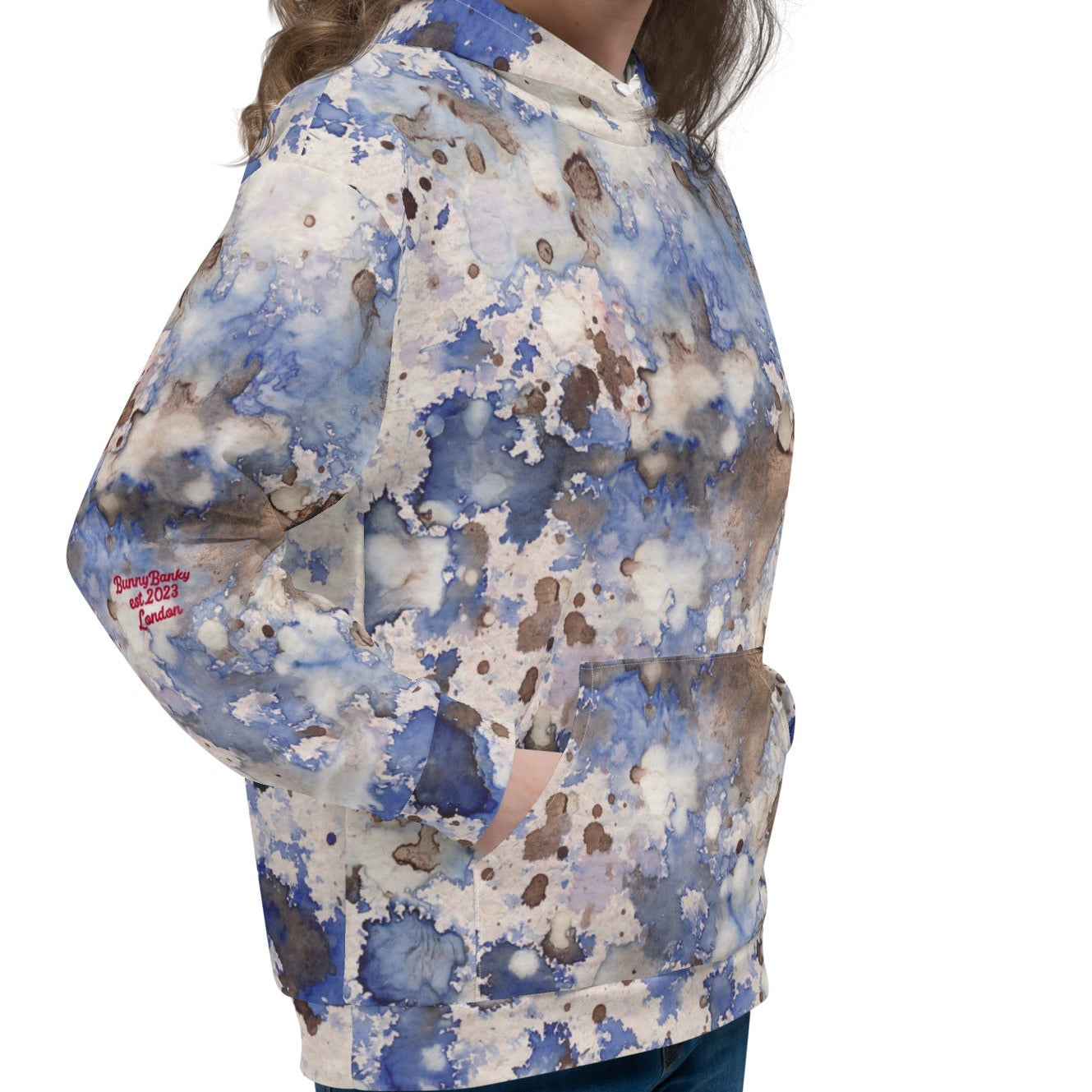 A  model wearing the Amalfi Resort Hoodie. The image showcases the fluid light blue, beige, and brown 