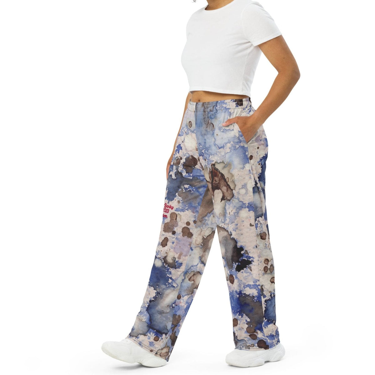 A model wearing the Amalfi Resort flow joggers in a blue and white abstract print  posing against a solid white background.