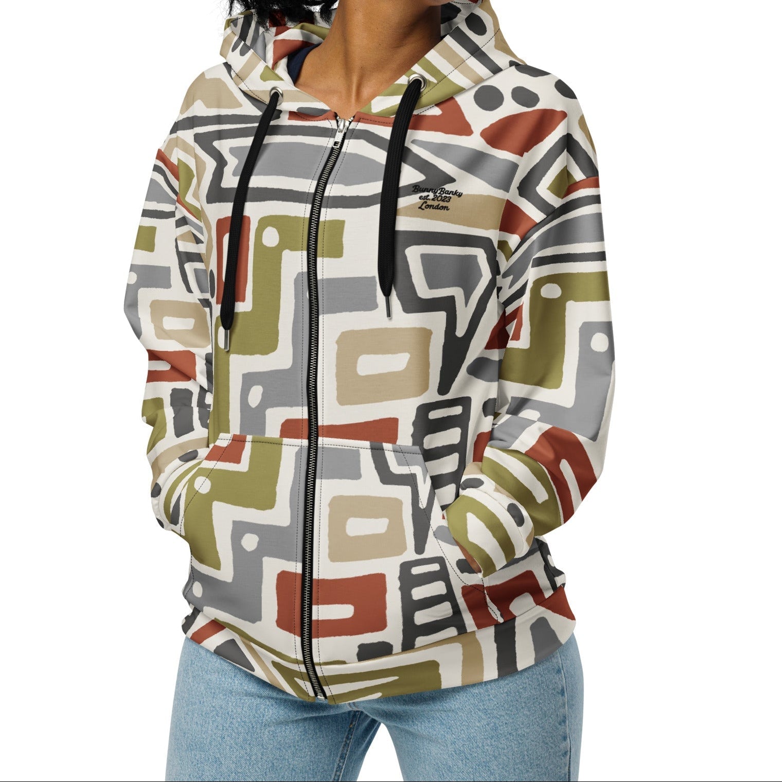 A model wearing The Amsterdam Zip Hoodie from BunnyBankY, showing the secure fit and the geometric futurism pattern in rich, earthy tones.