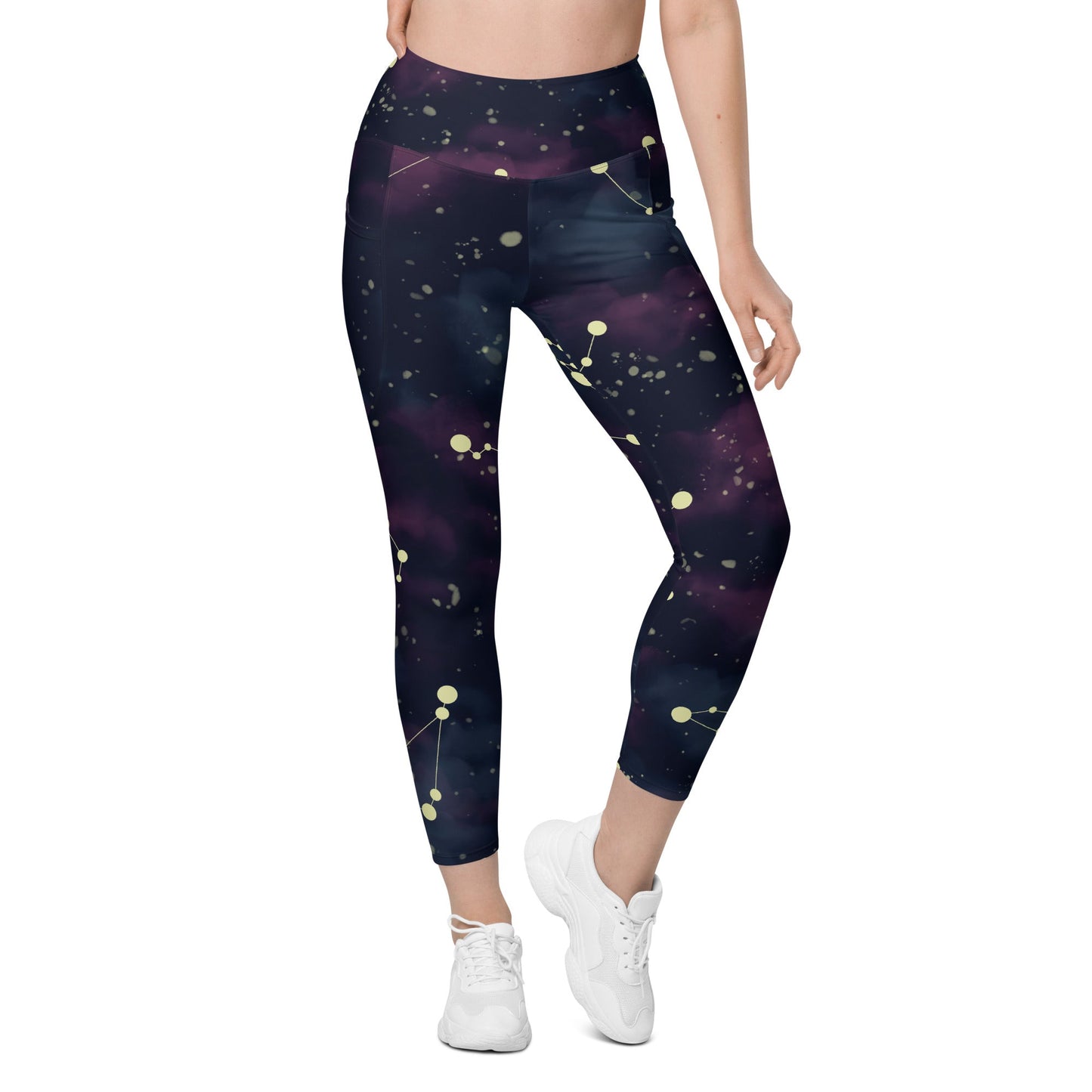 A model wearing The Andromeda Sculpt Leggings, showcasing the sculpting fit and the distinctive yellow star constellation print on the dark purple-to-black gradient fabric. The background features a subtle cosmic nebula.