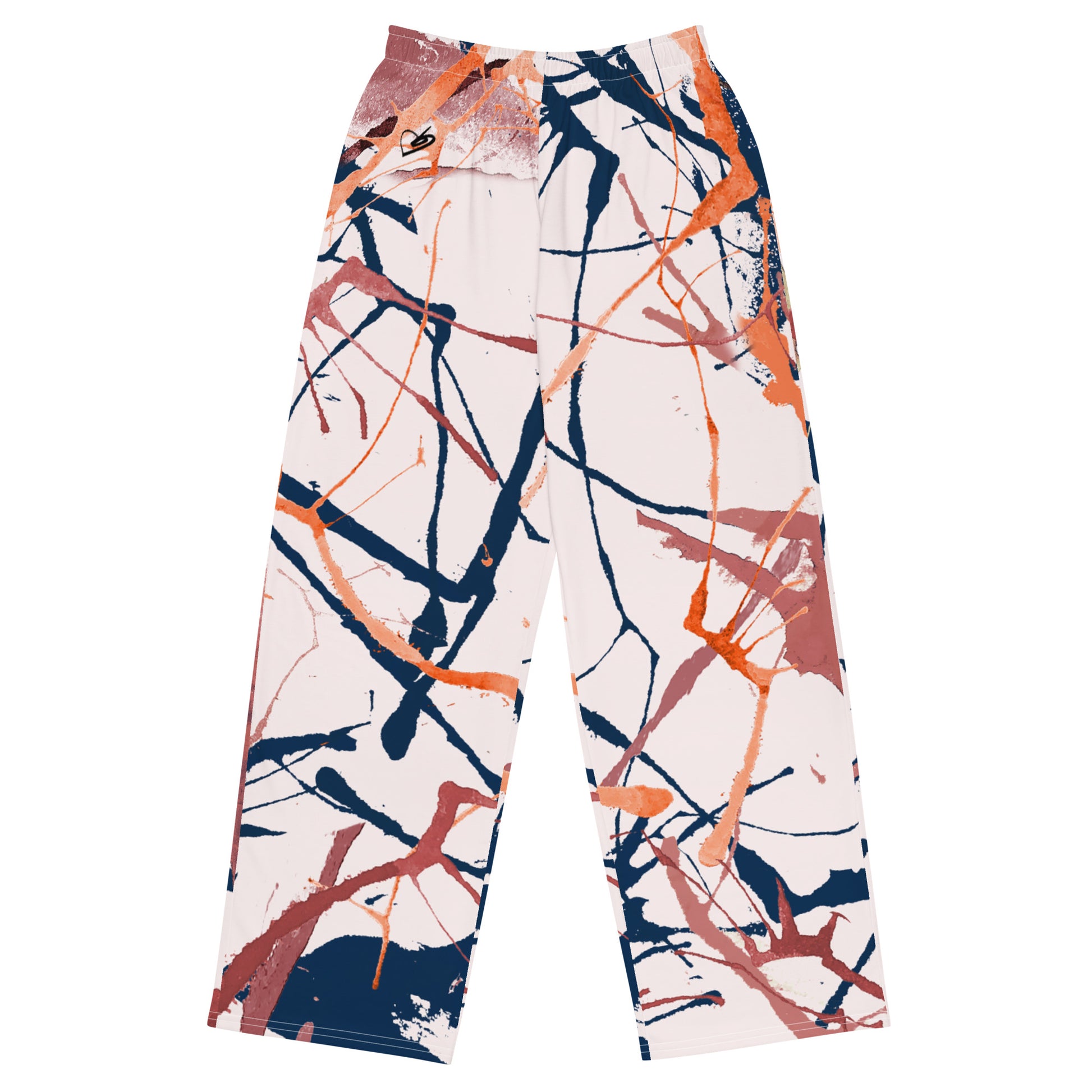 A pair of wide-leg pants featuring an abstract paint splatter pattern in orange, navy blue, and terracotta on a cream background, shown flat against a white background.