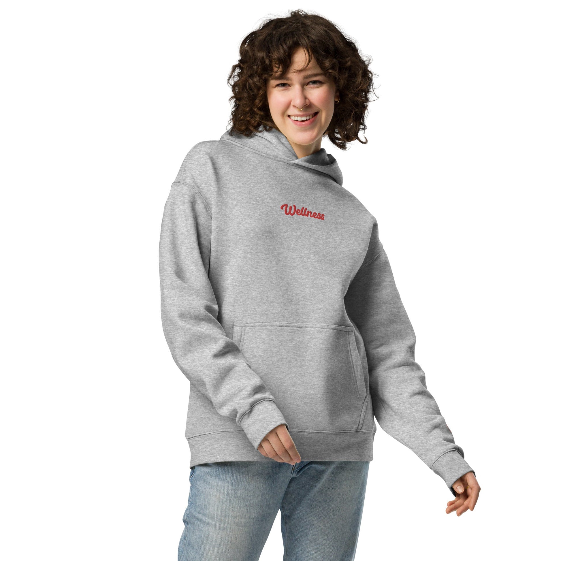 A model wearing The Angel Wellness Hoodie, showing the oversized fit and the embroidered "Wellness" text on the chest.