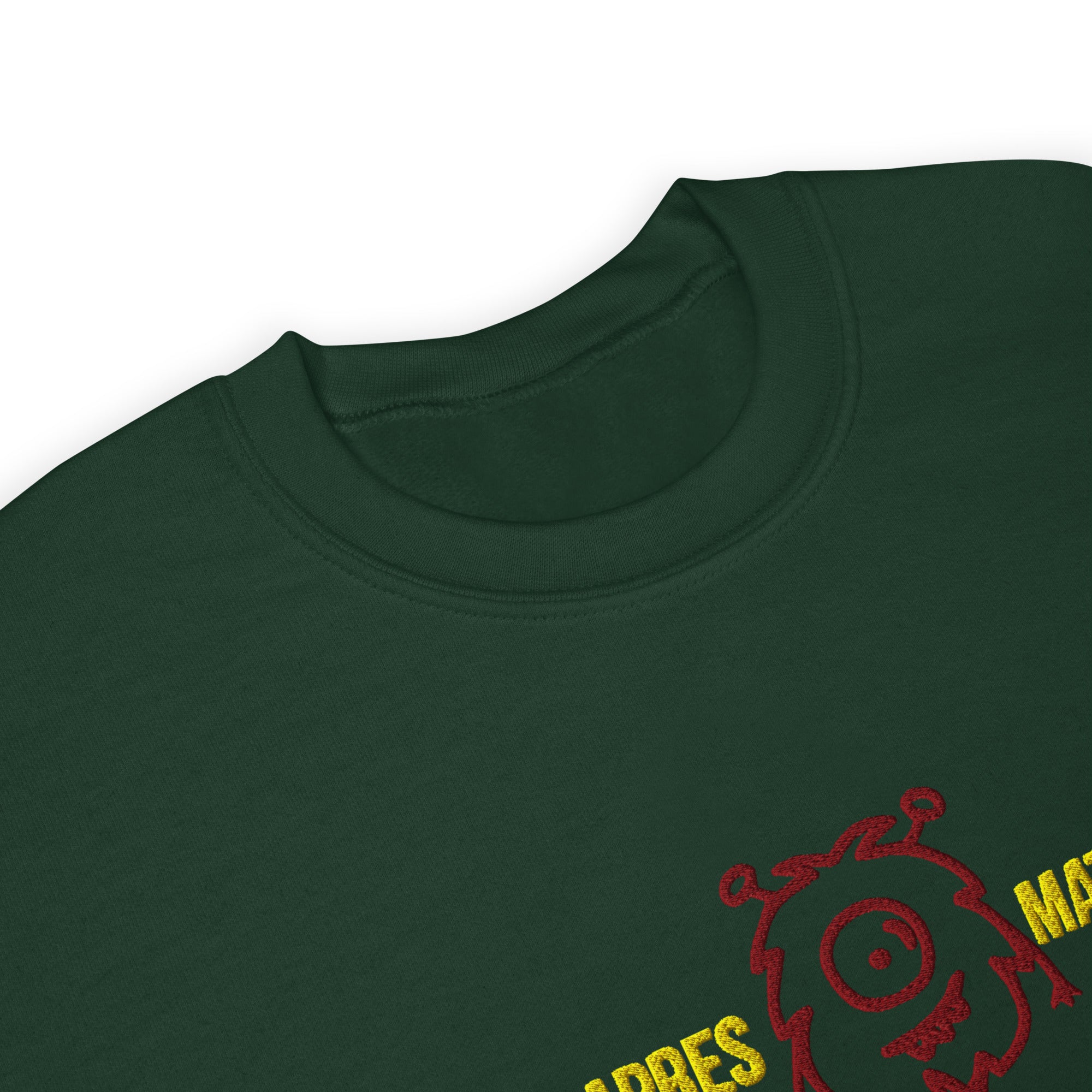 Close-up of the apres matcha sweatshirt,  dark green crewneck t-shirt featuring a red embroidered monster graphic and yellow text on the lower right chest.