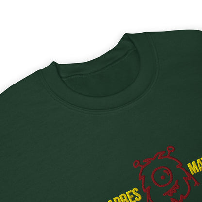 Close-up of the apres matcha sweatshirt,  dark green crewneck t-shirt featuring a red embroidered monster graphic and yellow text on the lower right chest.