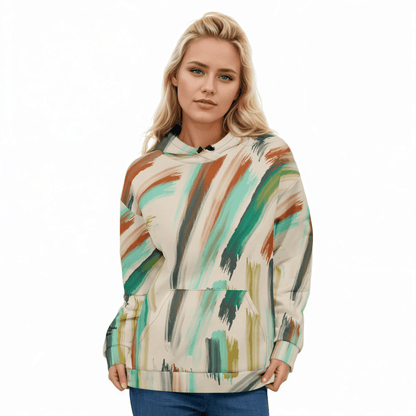 A model wearing The Artful Aura Hoodie, showing the relaxed, oversized fit and the soft pastel green brushstroke print on a beige background.