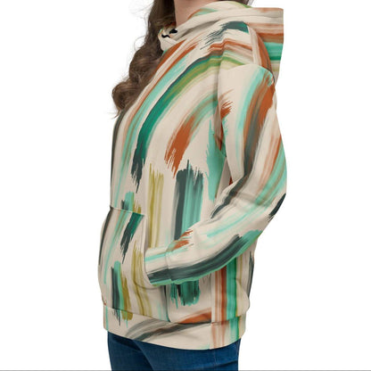 A model wearing The Artful Aura Hoodie, showing the relaxed, oversized fit and the soft pastel green brushstroke print on a beige background.